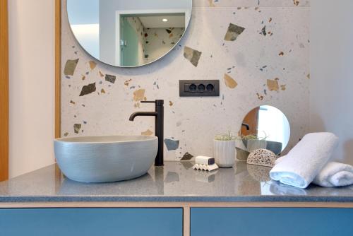 a bathroom with a sink and a mirror on a counter at Charisma Boutique Hotel in Parga