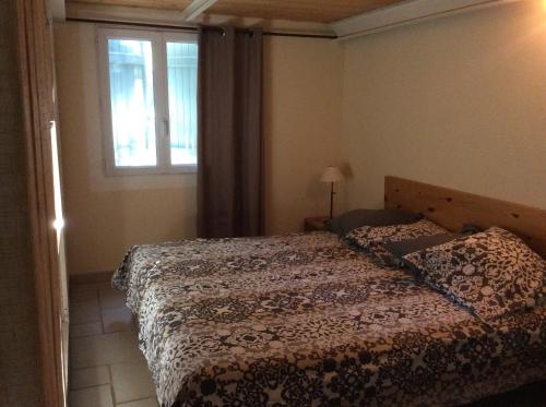 um quarto com uma cama e uma janela em Le Bois De La Cour em Roussillon