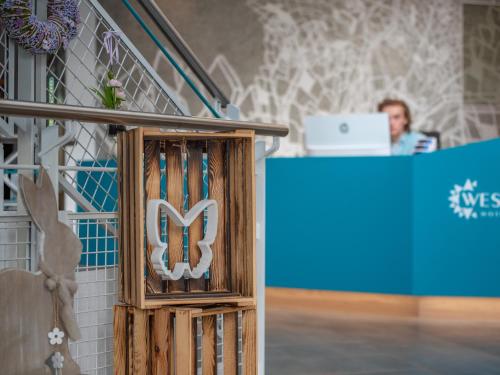 a person sitting at a desk with a laptop at WESTSIDE Hotel in Munich