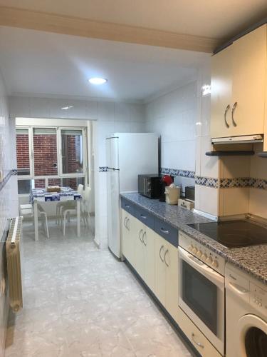 a kitchen with a white refrigerator and a table at Puro encanto II en el corazón de Santo Domingo in Santo Domingo de la Calzada
