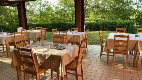 a dining room with tables and chairs in a conservatory at Agriturismo Rossococomero in Sirolo