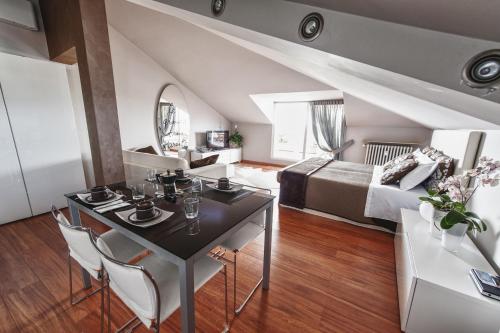 a living room with a table and a bedroom at Cute & Cozy Terrace in Bergamo
