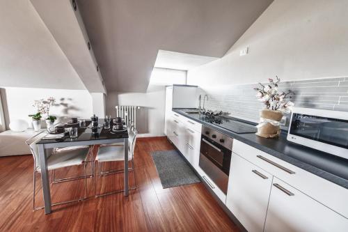 a large kitchen with a table and a microwave at Cute & Cozy Terrace in Bergamo