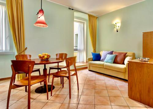 a living room with a table and chairs and a couch at Residence San Giusto in Trieste