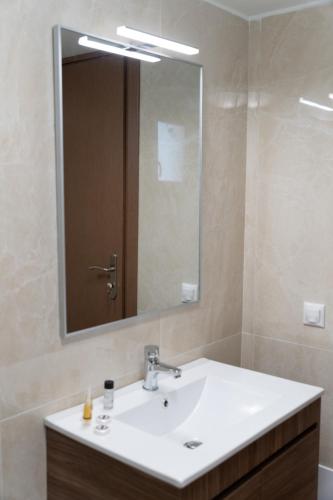 a bathroom with a white sink and a mirror at Dictamus Homes in Magoulás