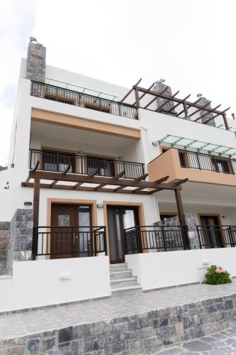 a house with white walls and balconies at Dictamus Homes in Magoulás