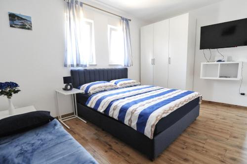a bedroom with two beds and a flat screen tv at Apartmani Rebecca in Vir