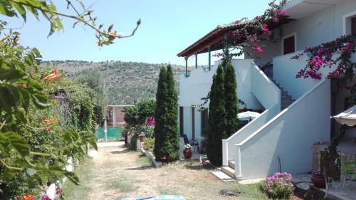 una casa con una escalera y árboles y flores en Baci Apartments, en Ksamil