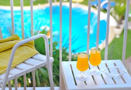 two glasses of orange juice sitting on a chair at GHT Balmes, Hotel-Aparthotel&SPLASH in Calella