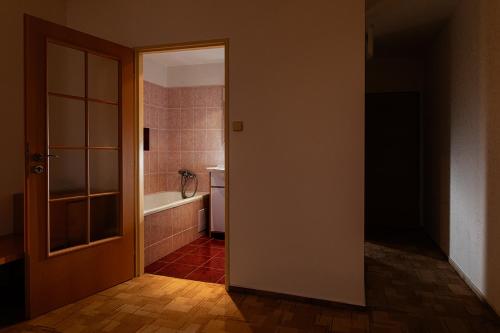 een open deur naar een badkamer met een bad bij Hotel Slezan in Bruntál