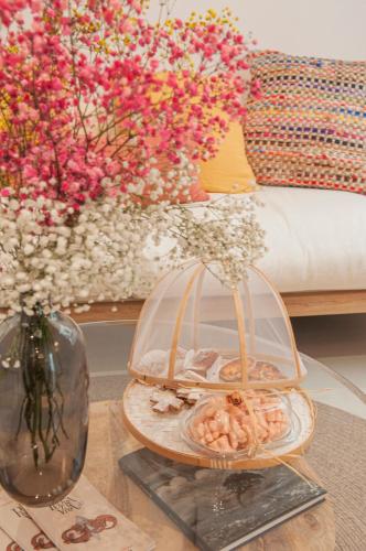 a glass table with a plate of food and a vase of flowers at 971 Hotel Con Encanto in Ciutadella
