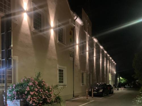 a building with flowers on the side of it at night at Hotel Stadt Kamen in Kamen