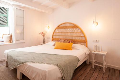 a bedroom with a large bed with a yellow pillow at 971 Hotel Con Encanto in Ciutadella