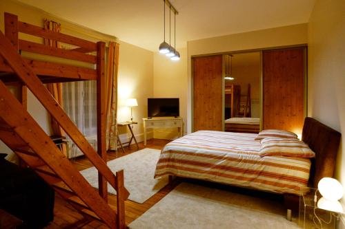 - une chambre avec un grand lit et un escalier dans l'établissement La Maison des Sources à la Ferme d'Auxonnettes, à Auxonnettes