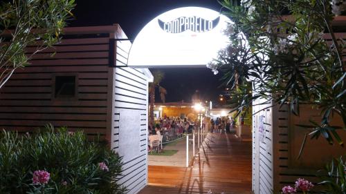 a crowd of people sitting at a restaurant at night at Three Rooms in Messina