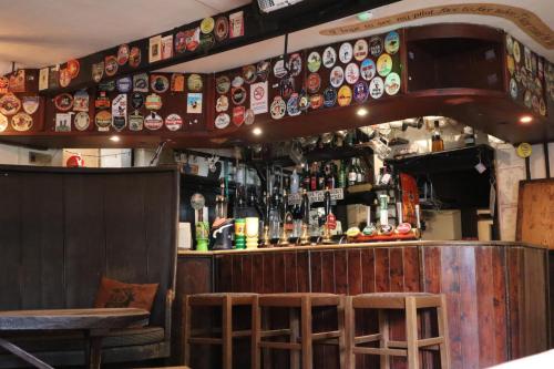 a bar with a lot of plates on the wall at The White Hart Inn in Tetford