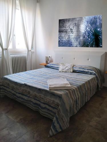 a bedroom with a bed with a painting on the wall at La California in Marina di Bibbona
