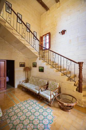 ein Wohnzimmer mit Treppe und Couch in der Unterkunft Dar ta' Tumas in Għarb
