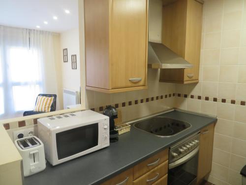a kitchen with a microwave and a sink at Coqueto apartamento Las Margas Golf in Sabiñánigo