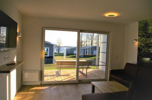 a living room with a sliding glass door to a patio at Witt am See A in Klein Wittensee