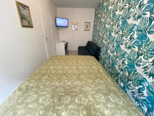 - une chambre dotée d'un lit avec un couvre-lit vert et blanc dans l'établissement 023 CHIC & COSY F1 23m2 HYPERCENTRE WIFI SMART TV NETFLIX, à Saint-Étienne