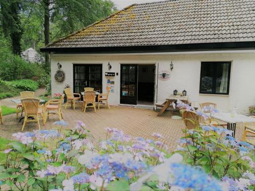 a house with a patio with tables and chairs at Herberg De Eexter Os in Eext