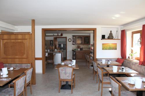 a dining room with tables and chairs in a restaurant at Hotel Bavaria in Bad Wiessee