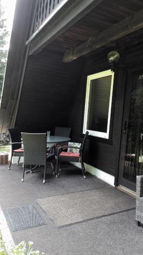 a patio with chairs and a table and a window at Finnhaus Neubauer in Elbingerode