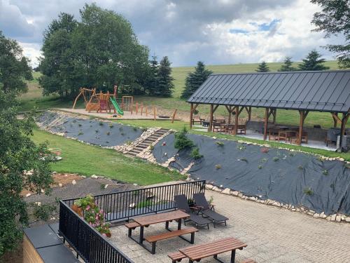 a park with benches and a playground with a picnic table at Penzion Kryštof in Kovářská