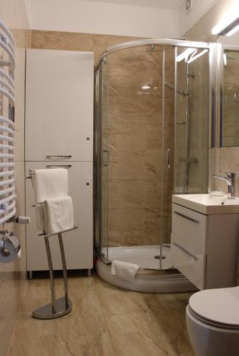 a bathroom with a shower and a toilet and a sink at Apartament Mariva B03 z ogródkiem - Pobierowo - blisko morza - przy kompleksie Grand Laola SPA in Pobierowo