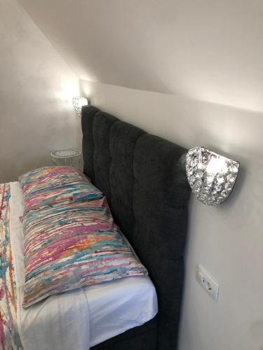 a black couch with a colorful pillow on a wall at Apartment Vid in Split