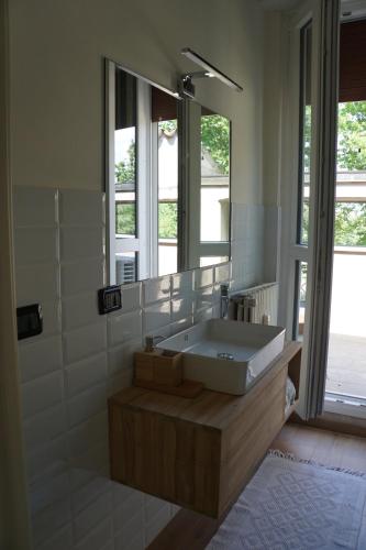 La salle de bains est pourvue d'un lavabo et d'un miroir. dans l'établissement La Rotonda 2 Camere con terrazza in centro, à Pavia