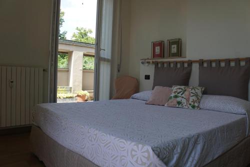 a bedroom with a bed with a blue comforter and a window at La Rotonda 2 Camere con terrazza in centro in Pavia