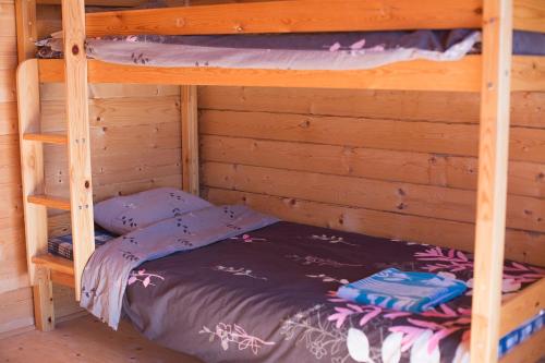 a bunk bed in a wooden room with a bunk bedsheet at Paradise Beach Surf Bugalow Small in Kalana