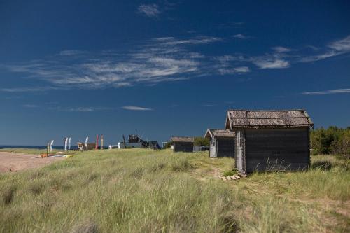 an old shack in a field of tall grass at Paradise Beach Surf Bugalow Small in Kalana