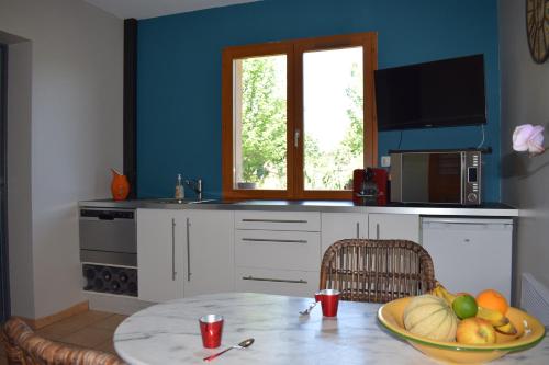 a kitchen with a table with a bowl of fruit at CB HOME in Audenge