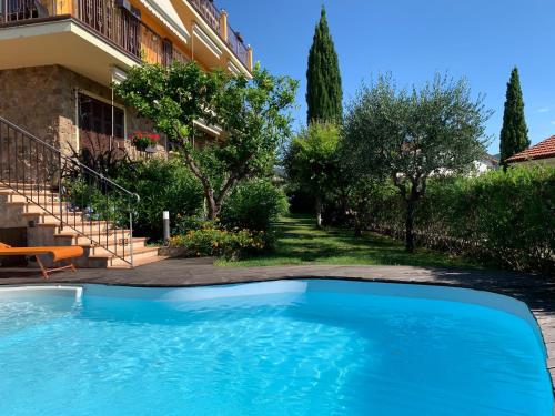 a swimming pool in front of a house at Villa Pineland in Borghetto Santo Spirito