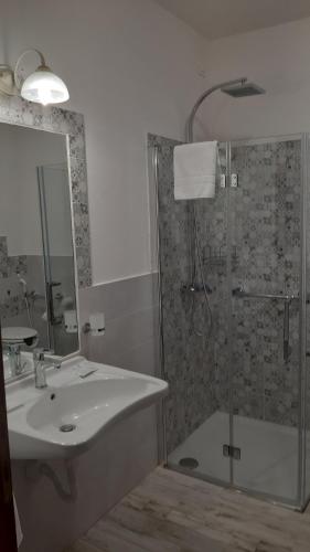 a bathroom with a sink and a shower with a glass door at Agriturismo Corte degli Angeli in Marina di Grosseto