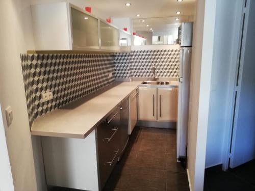 une petite cuisine avec un comptoir et un réfrigérateur dans l'établissement Paschke, à Cannes