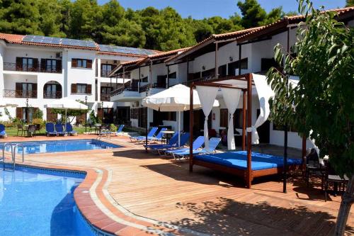 um hotel com uma piscina com cadeiras e guarda-sóis em Delphi Hotel em Neo Klima