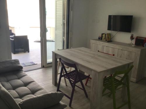 sala de estar con mesa de madera y sillas en Isuledda, en Isola Rossa
