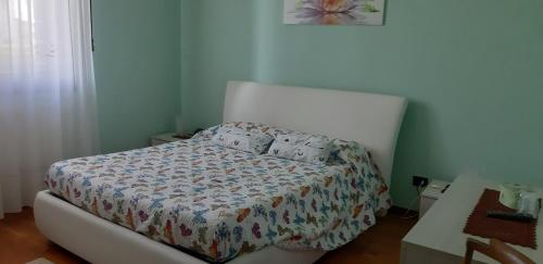 een kleine slaapkamer met een bed met een quilt bij Locazione Turistica alle Tre Civette in Noale