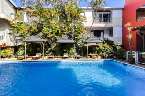 a swimming pool in front of a building at Sud Hôtel in Le Tampon