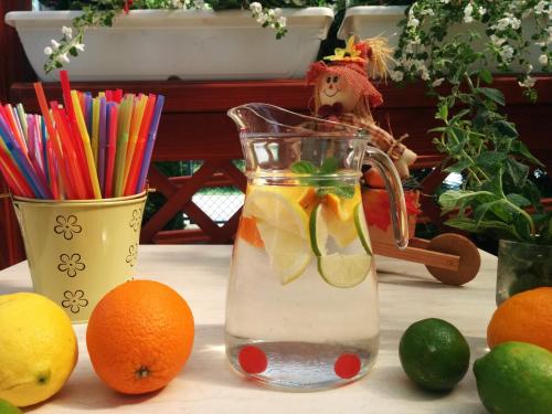 a glass pitcher of lemonade with oranges on a table at Boglárka Panzió - Étterem in Mezőkövesd
