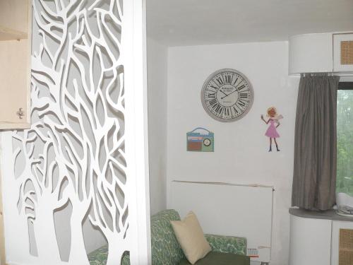 a living room with a clock on the wall at Liège centre 6 rue montagne sainte Walburge, 4000 Liège, pour 2 pers à 3 minutes de la gare st Lambert in Liège