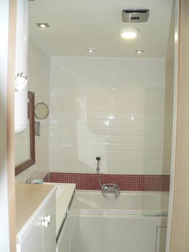 a bathroom with a tub and a red tile wall at Liège centre 6 rue montagne sainte Walburge, 4000 Liège, pour 2 pers à 3 minutes de la gare st Lambert in Liège