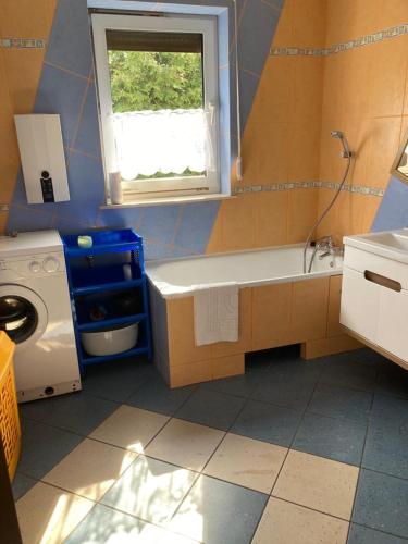 a bathroom with a tub and a sink and a window at Willa Janka in Pęczniew