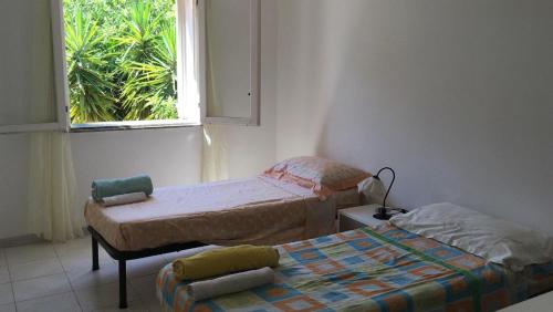 2 Einzelbetten in einem Zimmer mit Fenster in der Unterkunft trilocale "Lipari" in Portorosa in Torre Forte