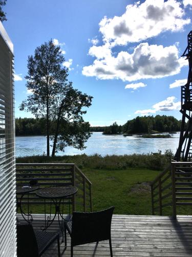 a patio with a table and chairs and a view of a river at Villa Kultaa in Kotka