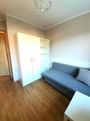 a living room with a blue couch and a cabinet at Apartament Gdańsk Wszędzie blisko , wysoki parter in Gdańsk